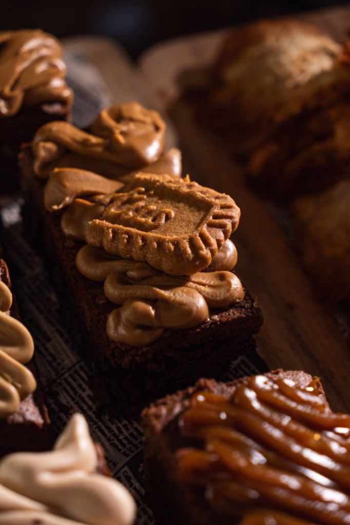 Primer plano cinematográfico de brownies con crema y galleta Lotus de El Epicúreo, fotografiado por Philipp Platner.