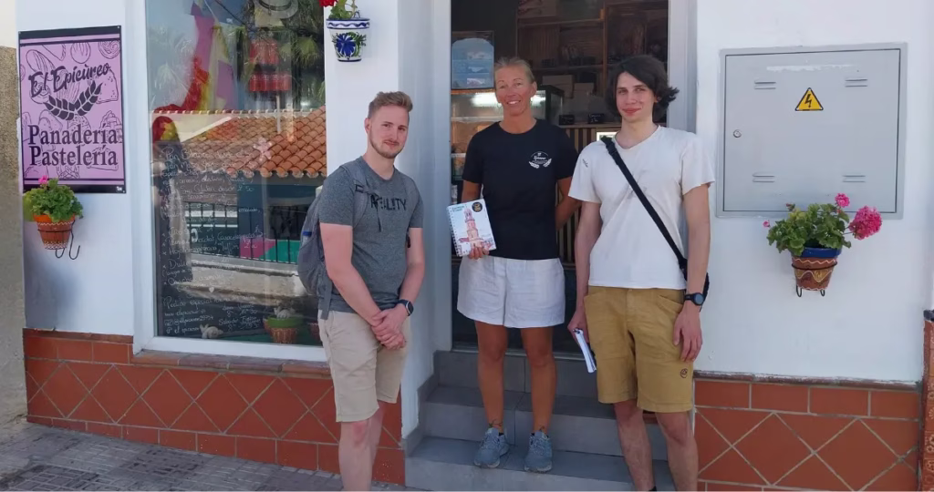 Virginie, dueña de El Epicúreo, junto a los estudiantes de Erasmus Matthias y Philipp en la entrada de la panadería en Cómpeta.