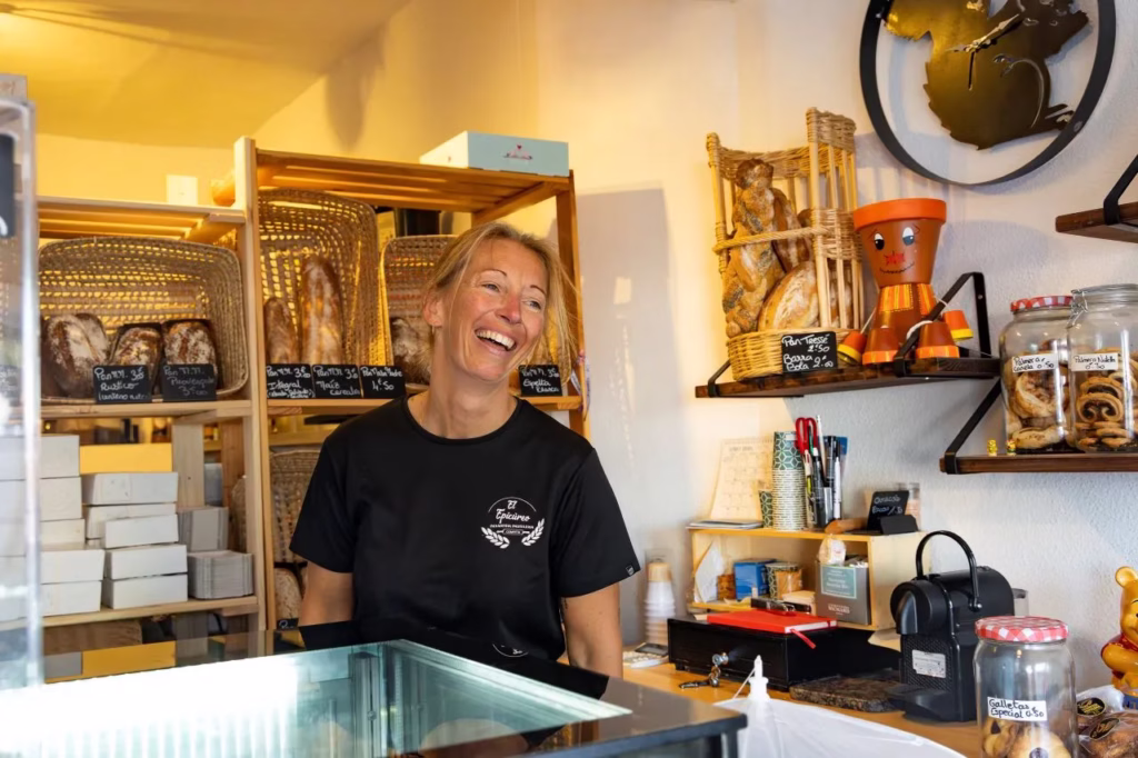 Virginie sonriendo detrás del mostrador de la panadería El Epicúreo, fotografía tomada por Matthias Winter.