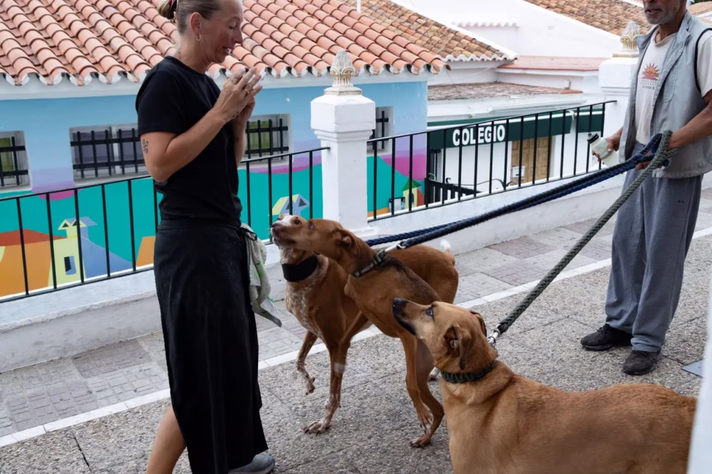 Virginie saludando cariñosamente a unos perros en las calles de Cómpeta, capturado por Matthias Winter.